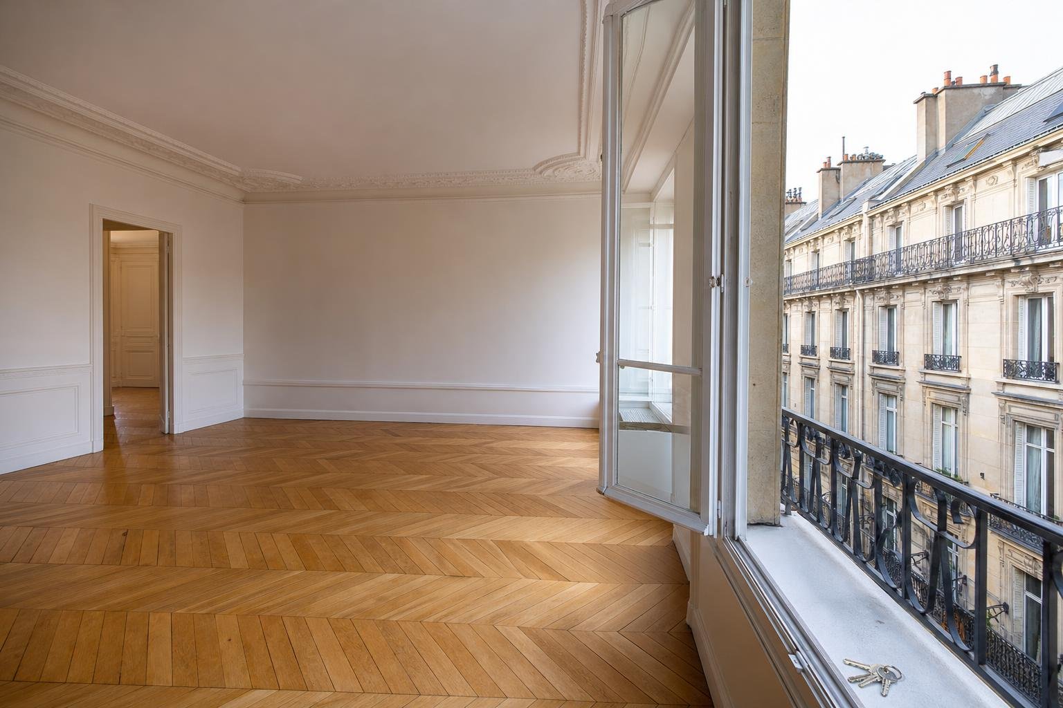 Appartement vide et lumineux d'un immeuble ancien, prêt à être loué, clés posées sur le rebord de la fenêtre